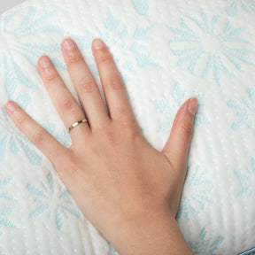 Close-up image of a hand on the Cooling Crescent Pillow cover showcasing the snowflake design