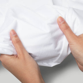 Image of two hands holding a Bamboo Mattress Protector