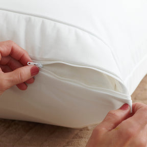 Image of two hands zipping a Bamboo Pillow Protector closed