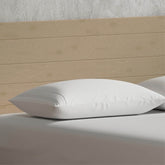 Image of a pillow with a Bamboo Pillow Protector on a tan bed