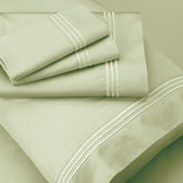 Image of Sage Recovery Cotton Shed Set shown top to bottom with two folded pillowcases, one flat sheet, a pillowcase shown on a pillow, and a fitted sheet underneath