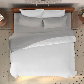 Top-down image of a dressed bed with Dove Gray Bamboo Rayon Sheets and a white duvet cover 