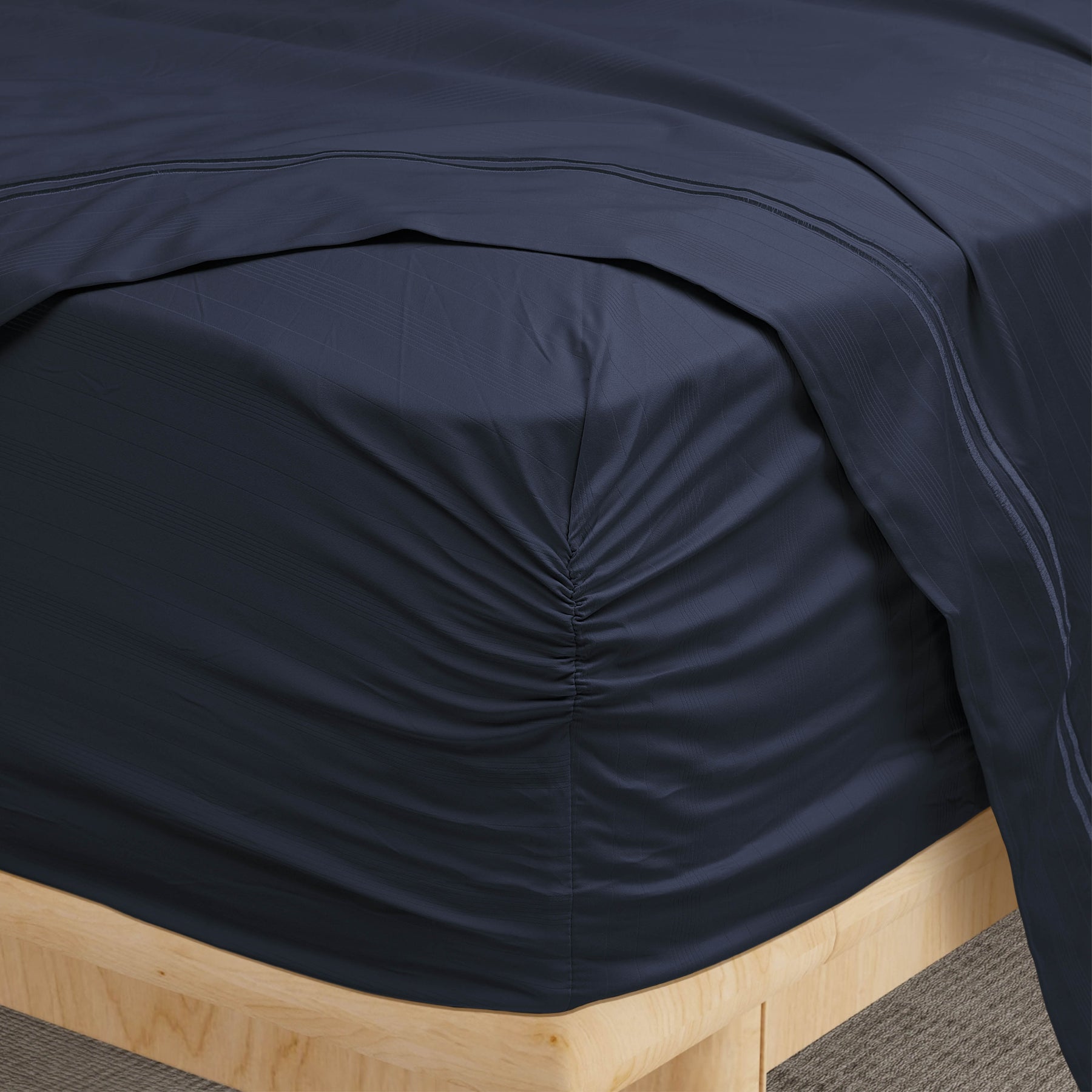 Image of a corner of a Midnight Bamboo Rayon fitted sheet showcasing the Precision-Fit® Corner