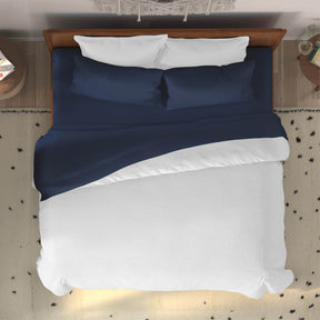 Top-down image of a dressed bed with Midnight Bamboo Rayon Sheets and a white duvet cover 