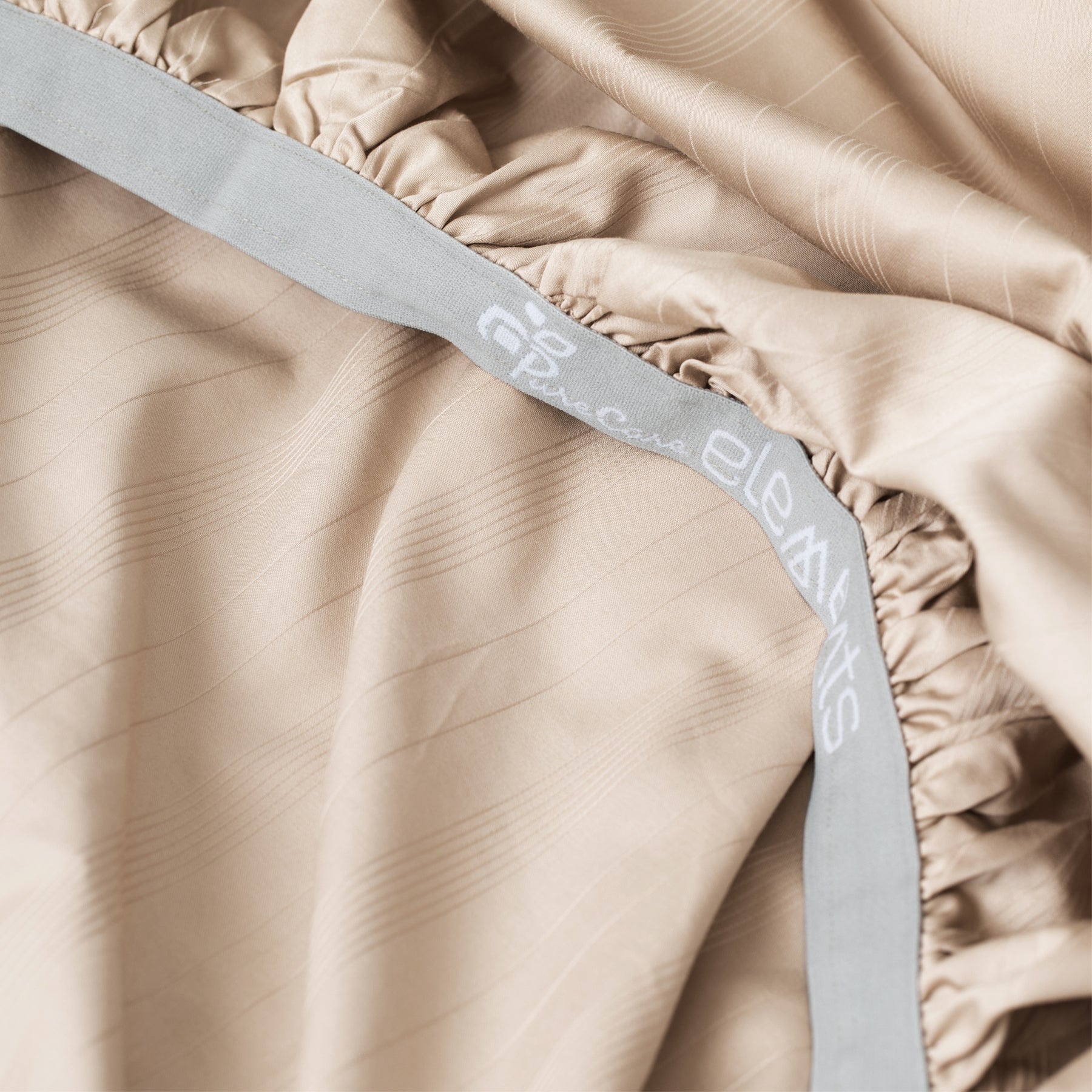 Image showcasing the Precision-Fit® elastic band on the bottom of a Sand Bamboo Rayon fitted sheet