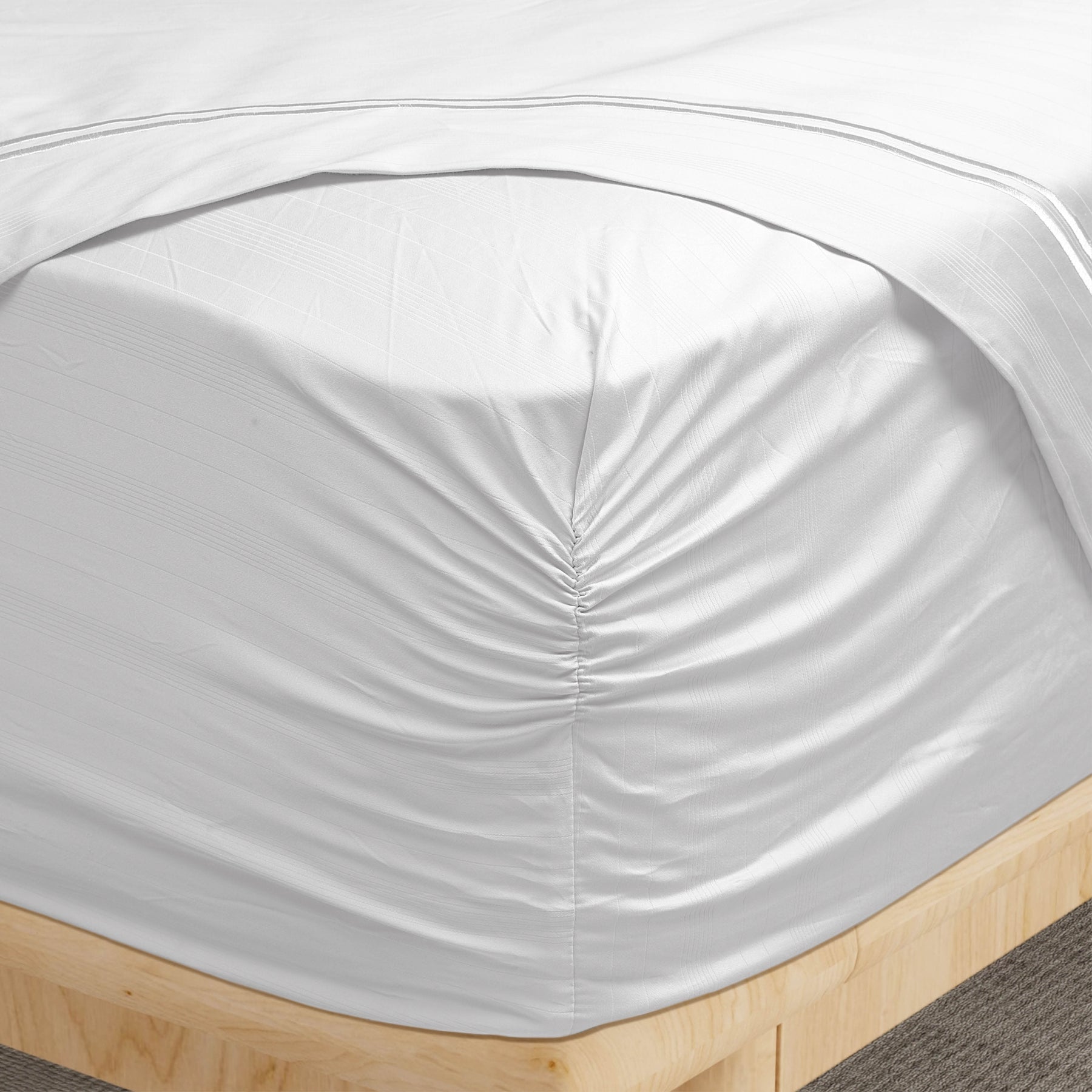 Image of a corner of a White Bamboo Rayon fitted sheet showcasing the Precision-Fit® Corner