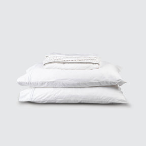 Image of White Refreshing TENCEL™ Lyocell Sheet Set stacked top to bottom: Flat Sheet, Fitted Sheet, 2 Pillowcases