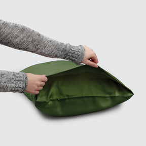 Image of a Moss Soft Touch TENCEL™ Modal Pillowcase on a pillow with a hand lifting up the edge to showcase the enveloping design