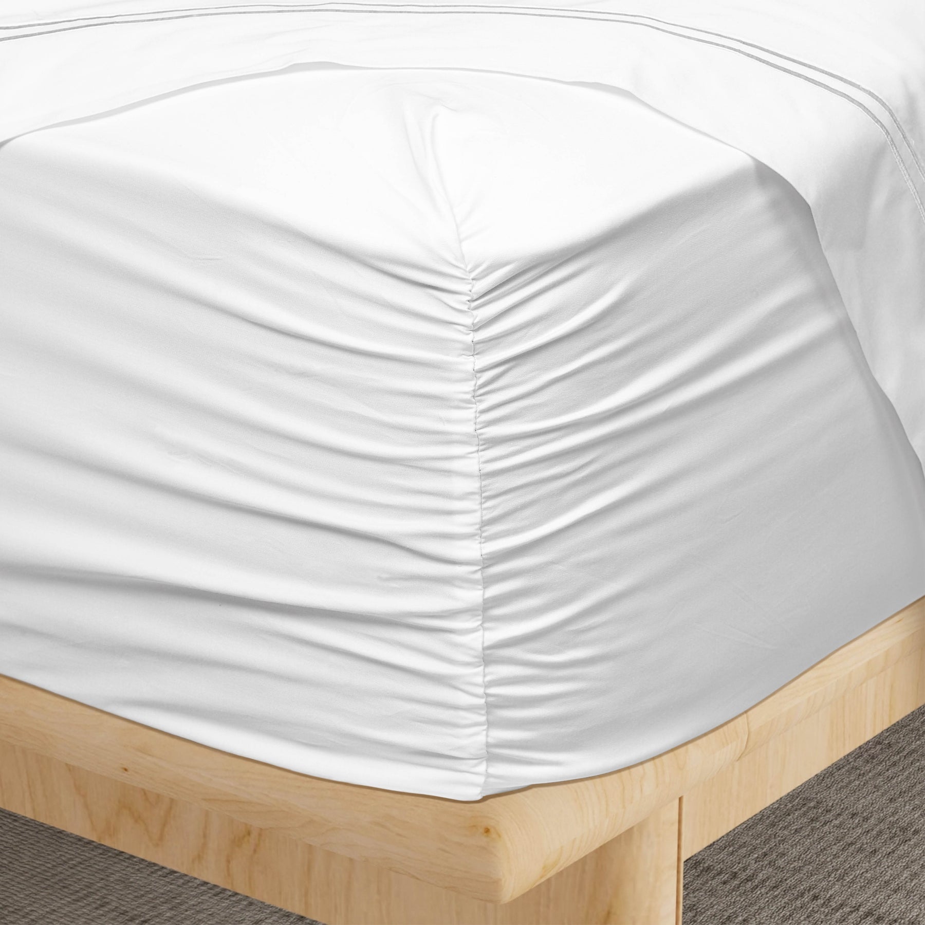 Image of a corner of a White Soft Touch TENCEL™ Modal fitted sheet showcasing the Precision-Fit® Corner