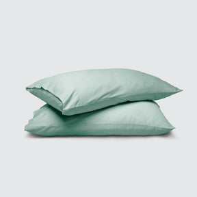 Image of two pillows stacked on top of one another with a Seafoam Weightless Cotton Pillowcase on each