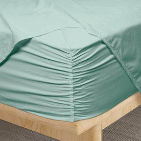 Image of a corner of a Seafoam Weightless Cotton fitted sheet showcasing the Precision-Fit® Corner