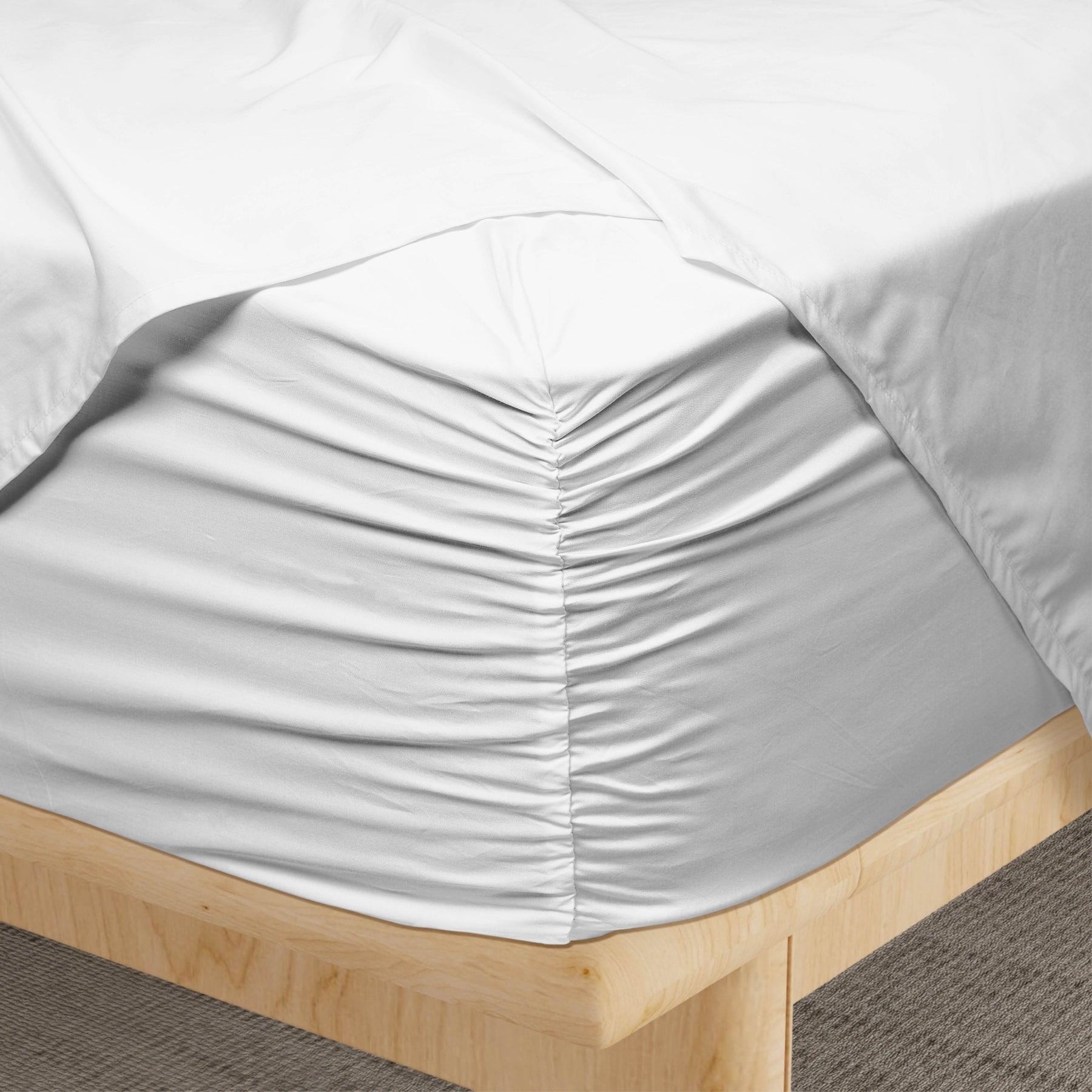 Image of a corner of a White Weightless Cotton fitted sheet showcasing the Precision-Fit® Corner