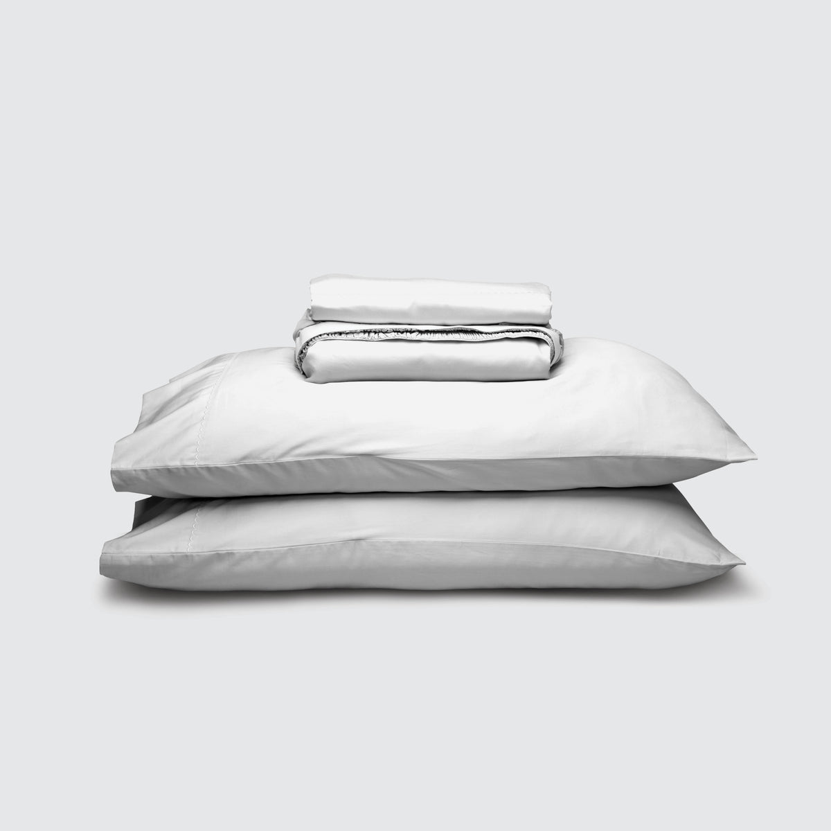 Image of White Weightless Cotton Sheet Set stacked top to bottom: Flat Sheet, Fitted Sheet, 2 Pillowcases