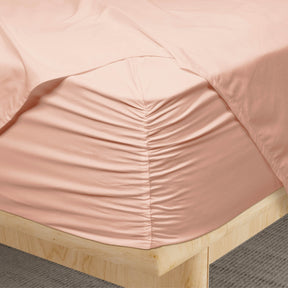 Image of a corner of a Blush Pink Weightless Cotton fitted sheet showcasing the Precision-Fit® Corner