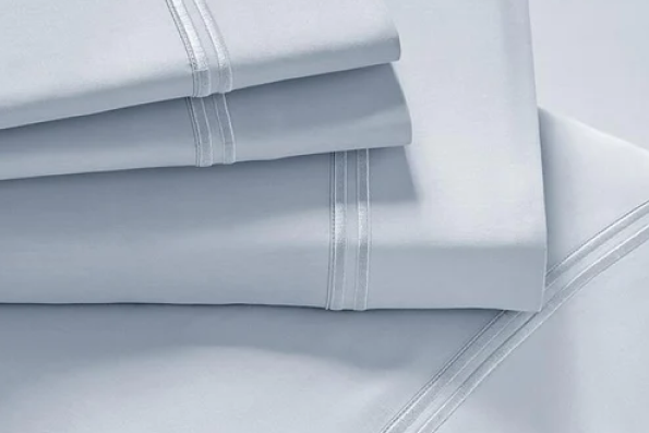 Image showcasing entire Light Blue Soft Touch TENCEL™ Modal Sheet Set. The image includes: a fitted sheet on the bed, a pillowcase on a pillow, a neatly folded flat sheet, and two neatly folded pillowcases.